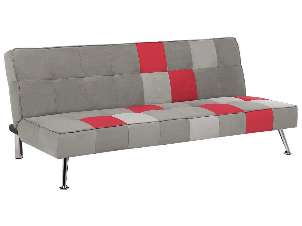 A modern futon sofa bed upholstered in a gray patchwork fabric with red and light gray square accents, supported by slim silver metal legs, shown on a plain white background.