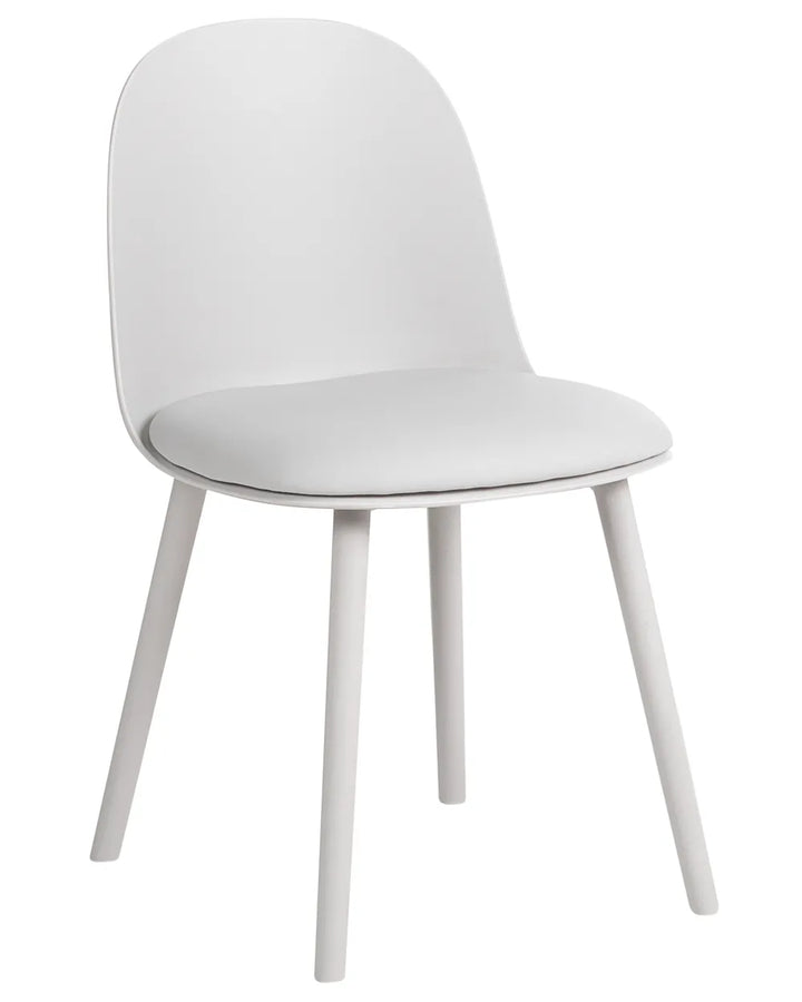 A modern white dining chair with a curved backrest, a padded seat cushion, and four tapered legs, shown against a plain white background.