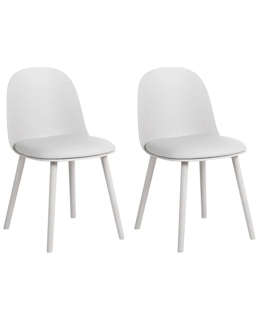 Two modern white dining chairs with curved backs and tapered legs, shown side by side on a plain white background.