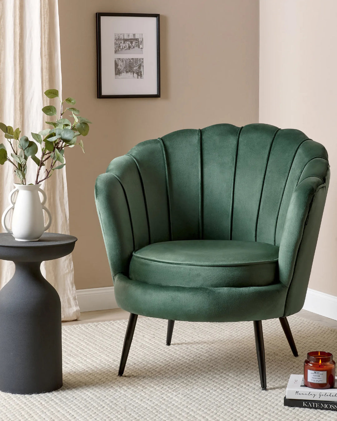 Green velvet armchair in a room with a side table and plant
