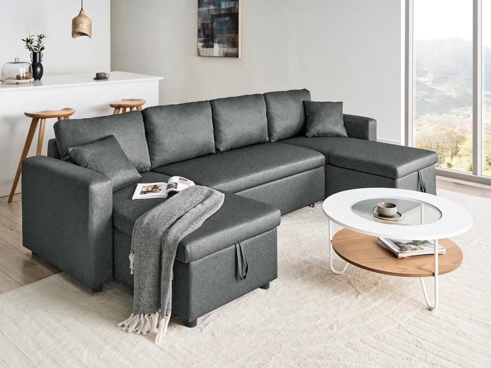 Gray sectional sofa in a modern living room with a coffee table and decor items.