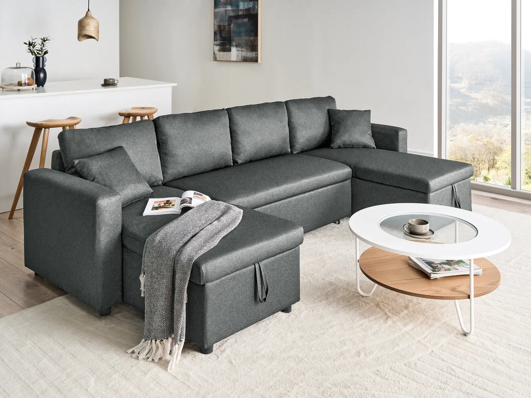 Gray sectional sofa in a modern living room with a coffee table and decor items.
