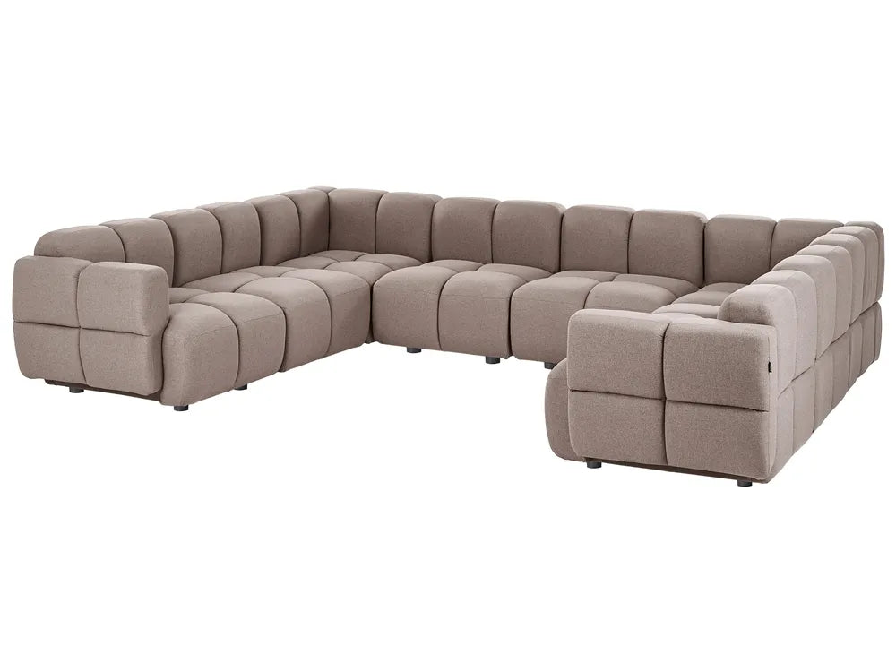 A modular sectional sofa upholstered in a textured taupe fabric, featuring a tufted grid pattern and blocky, modern design, shown on a plain white background.