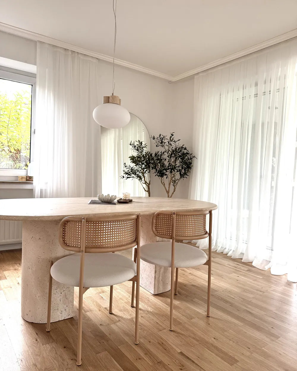 Modern dining area with a wooden table and chairs in a bright room.
