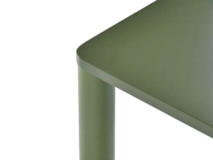 Close-up of a modern table corner with a rounded top and cylindrical leg in a muted sage green color, set against a plain white background.