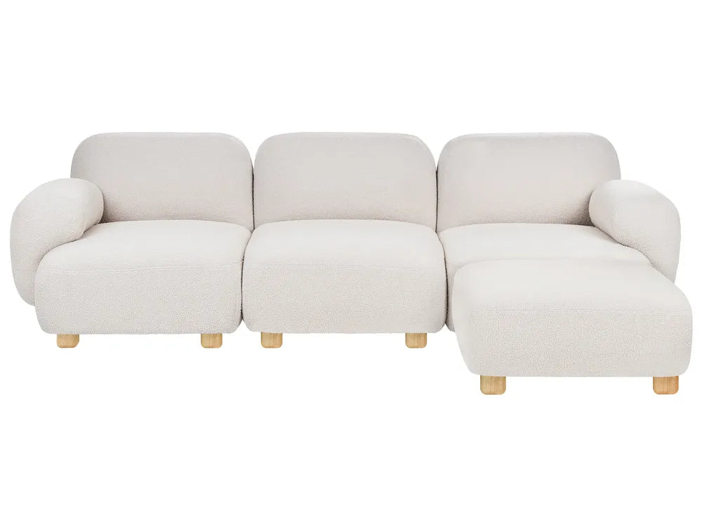 A modern three-seater sofa with a right-side chaise lounge, upholstered in a textured cream bouclé fabric and supported by light natural wood legs, shown against a plain white background.