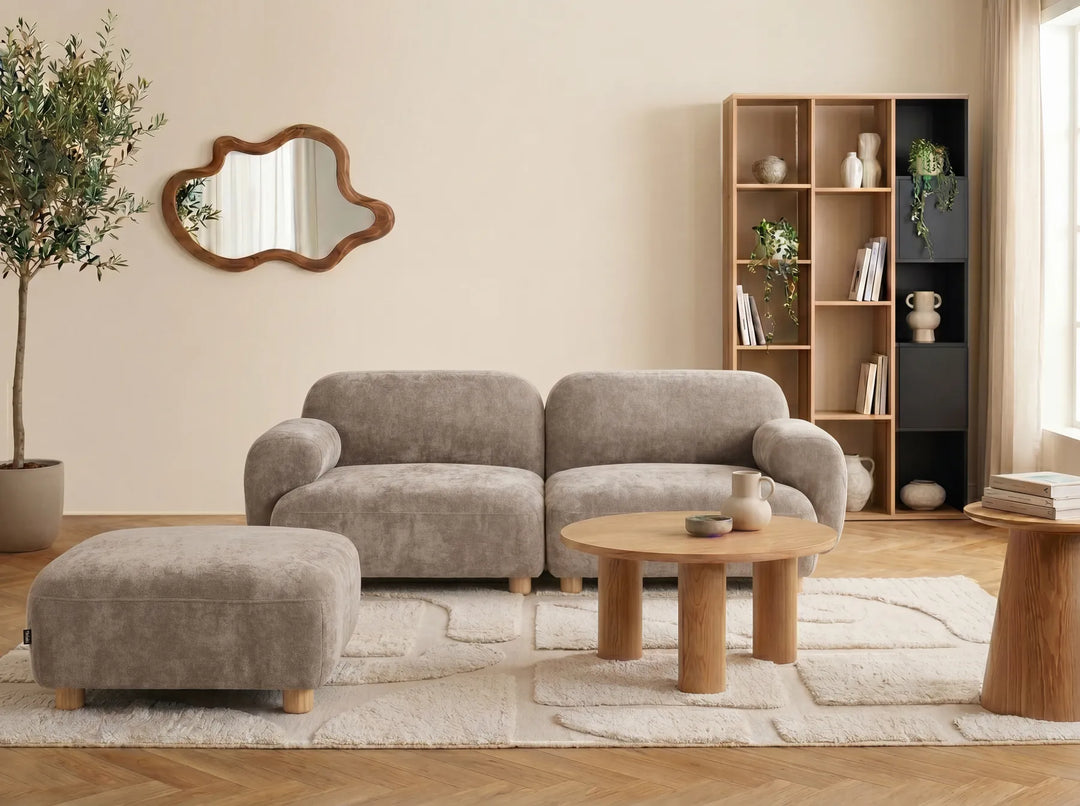 A modern two-seater sofa with a matching ottoman, upholstered in a textured taupe fabric with light wood legs.