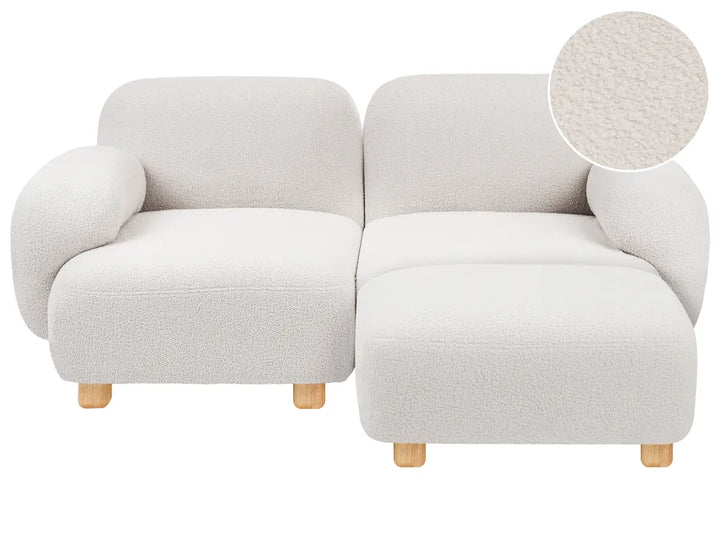 A modern two-seat sofa upholstered in a textured boucle fabric in a warm off-white/cream color, with light natural wood legs and a circular fabric close-up inset in the top right corner.