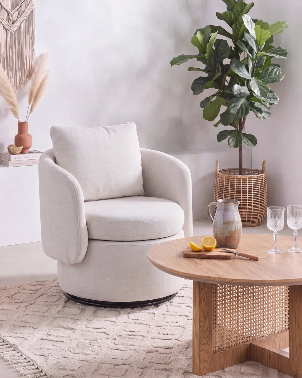 A cream upholstered barrel-style armchair.