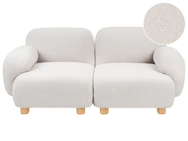 A modern two-seater sofa upholstered in a textured bouclé fabric, shown on a plain white background with a circular fabric close-up inset in the top right.