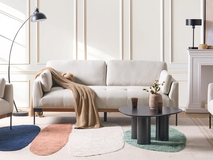 Modern living room with a beige sofa, coffee table, and decorative items.