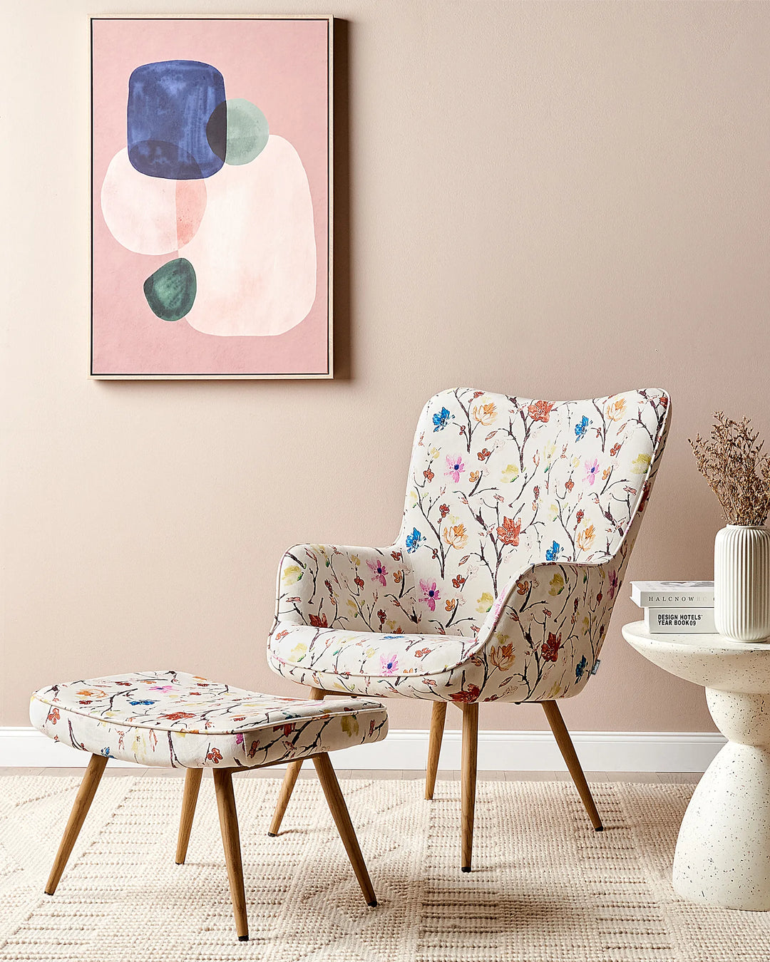 Floral-patterned chair and ottoman in a room with abstract art on the wall.
