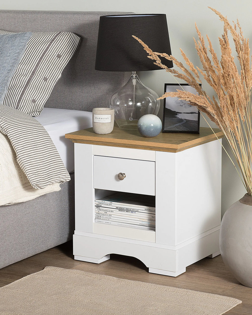 White nightstand with wooden top in a bedroom setting