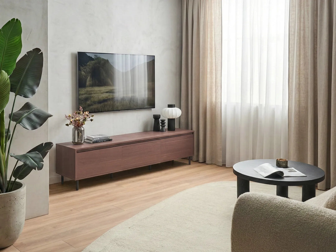 Modern living room with a wooden TV stand, television, and decor items.