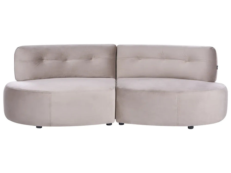 A modern curved modular sofa upholstered in a light taupe-beige velvet fabric, featuring tufted backrests and small black feet, shown against a plain white background.