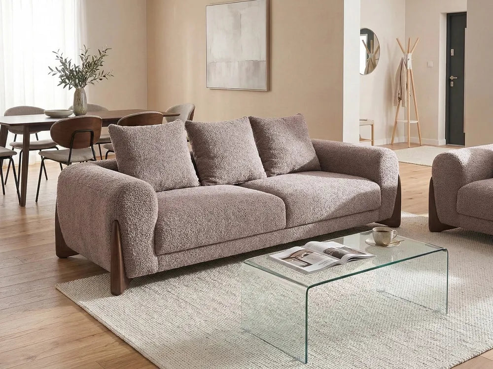 Living room with a gray sofa, glass coffee table, and wooden chairs.