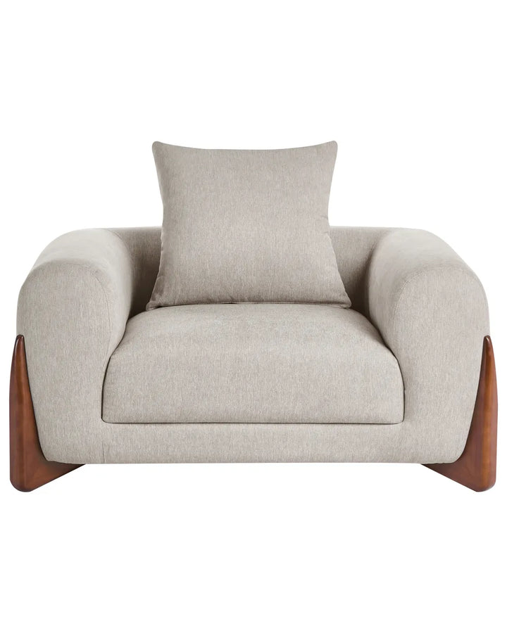 Beige armchair with wooden legs and a matching pillow on a white background