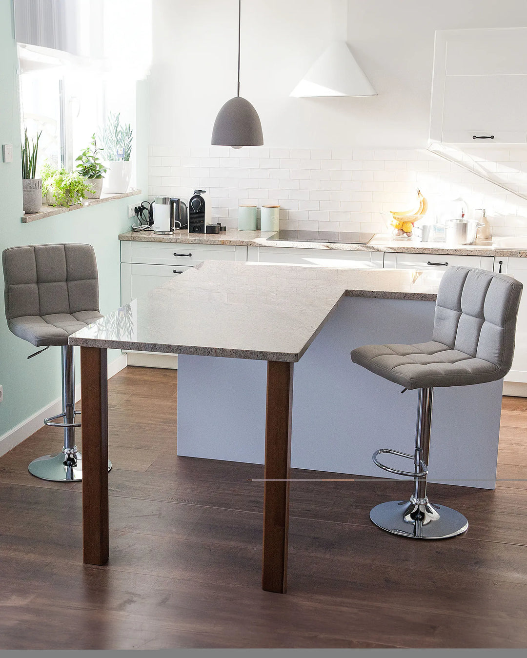 Modern kitchen with a wooden dining table and gray bar stools.