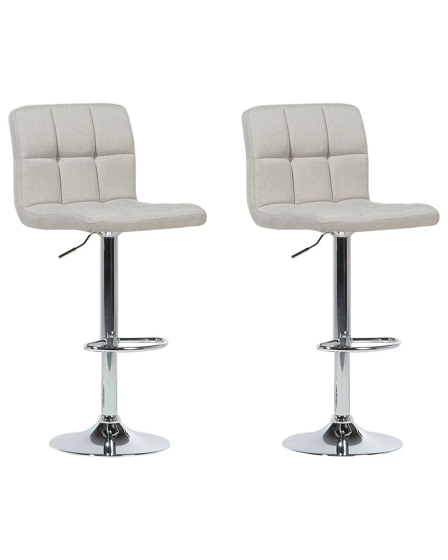 Two beige bar stools with quilted seats on a white background