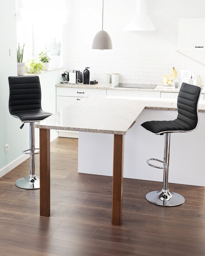 Modern kitchen with a white dining table and black bar stools.