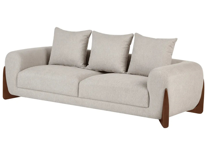A modern three-seat sofa upholstered in a light beige textured fabric, featuring three matching back cushions and dark brown wooden legs, shown against a plain white background.
