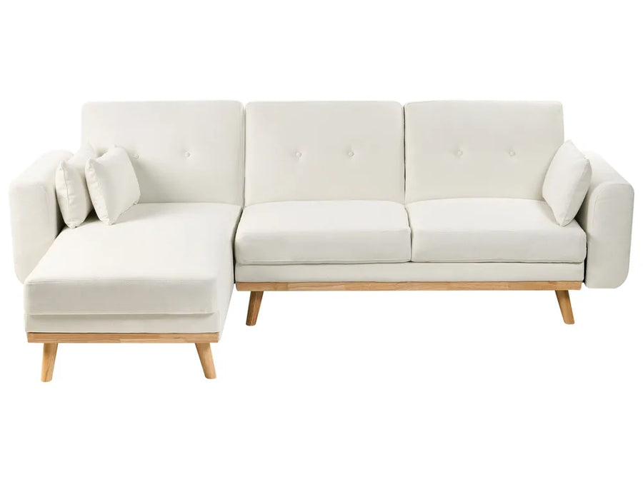 A modern sectional sofa in off-white fabric with a left-facing chaise lounge, tufted back cushions, and light natural wood legs, shown against a plain white background.