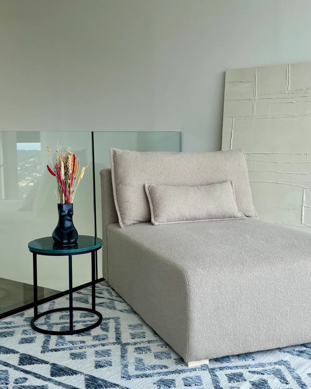 Modern bedroom with a bed, side table, and decorative elements.