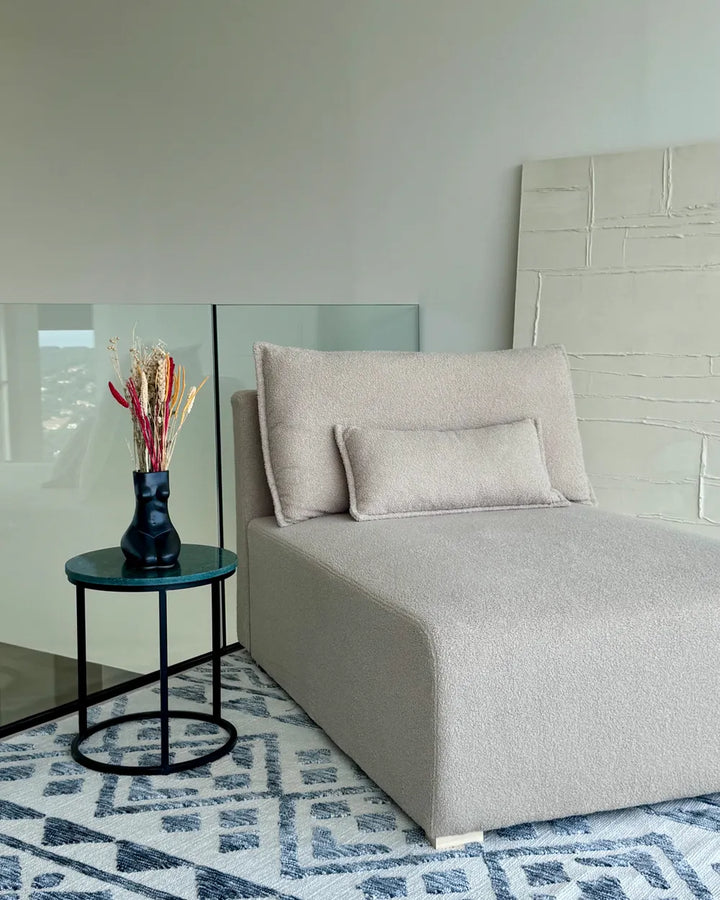Modern bedroom with a bed, side table, and decorative elements.
