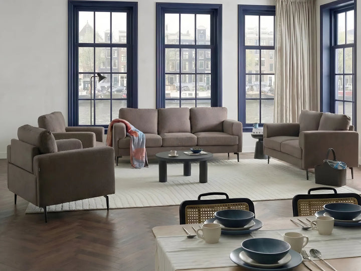 Modern living room with gray sofa, armchairs, and a dining table set.