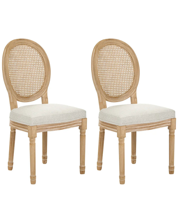 Two matching dining chairs with oval cane backrests and light beige upholstered seats, shown on a plain white background.