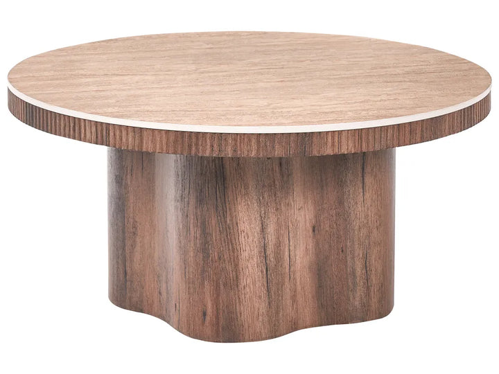 A round wooden table with a light beige top and a dark brown pedestal base featuring a wavy bottom edge, shown on a solid white background.