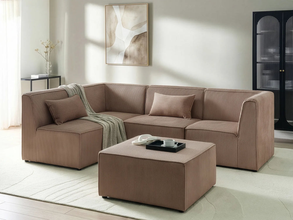 A modern L-shaped sectional sofa in a warm taupe-brown corduroy fabric, paired with a matching square ottoman and a beige throw blanket, set in a bright, contemporary living room.