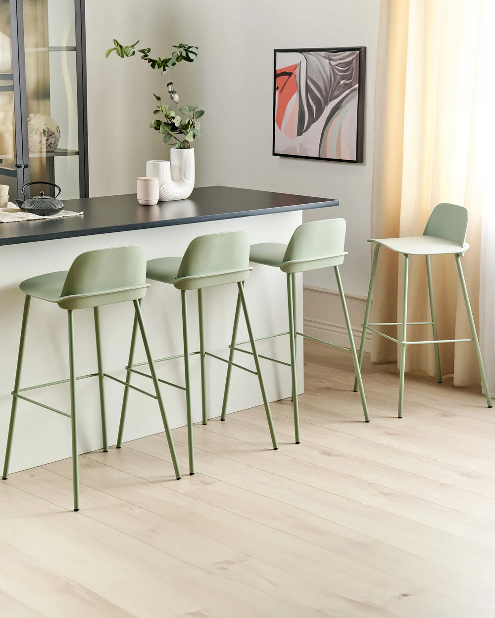 Green bar stools in a modern kitchen setting with a countertop and decor.
