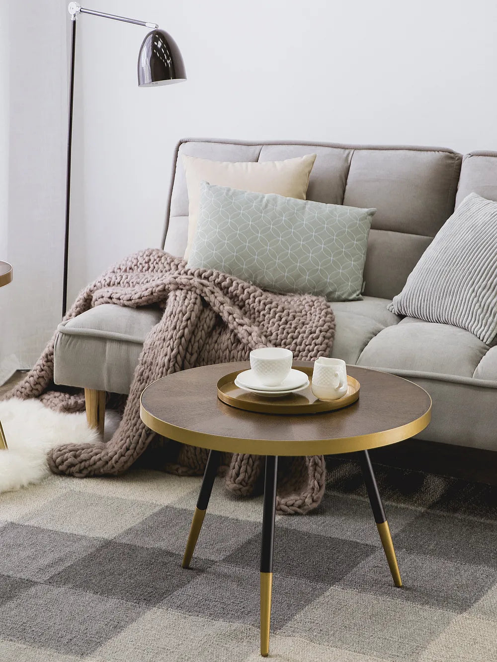 Living room with a gray sofa, coffee table, and decorative items.