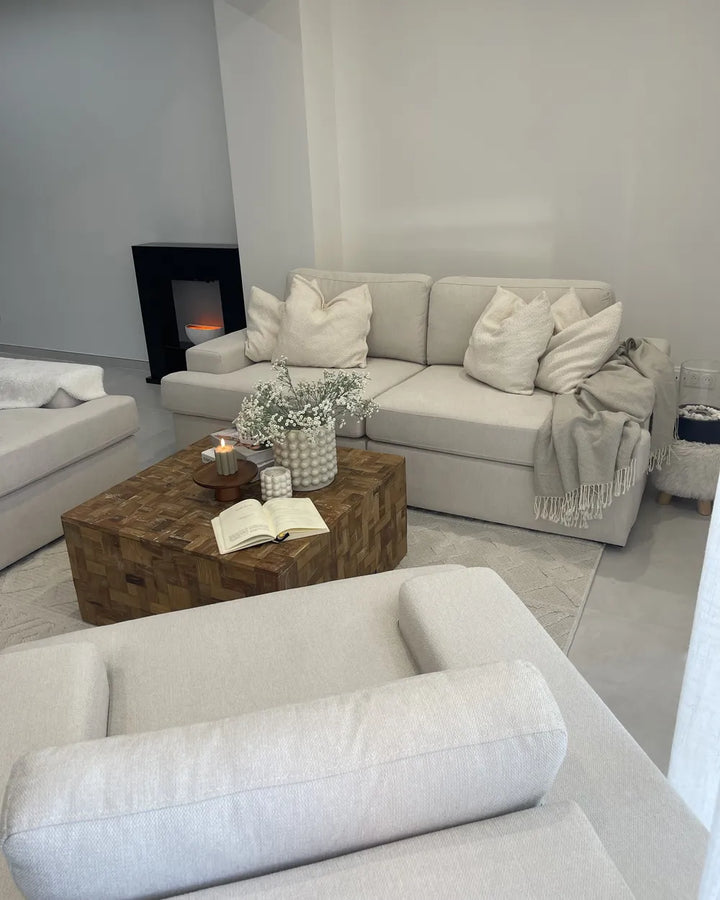 Modern living room with gray sofas, wooden coffee table, and decorative elements.