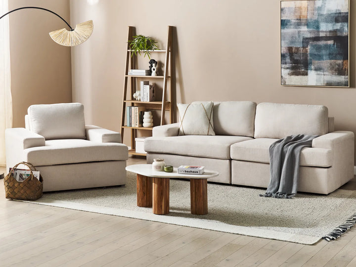 Modern living room with beige sofa, armchair, and wooden coffee table.