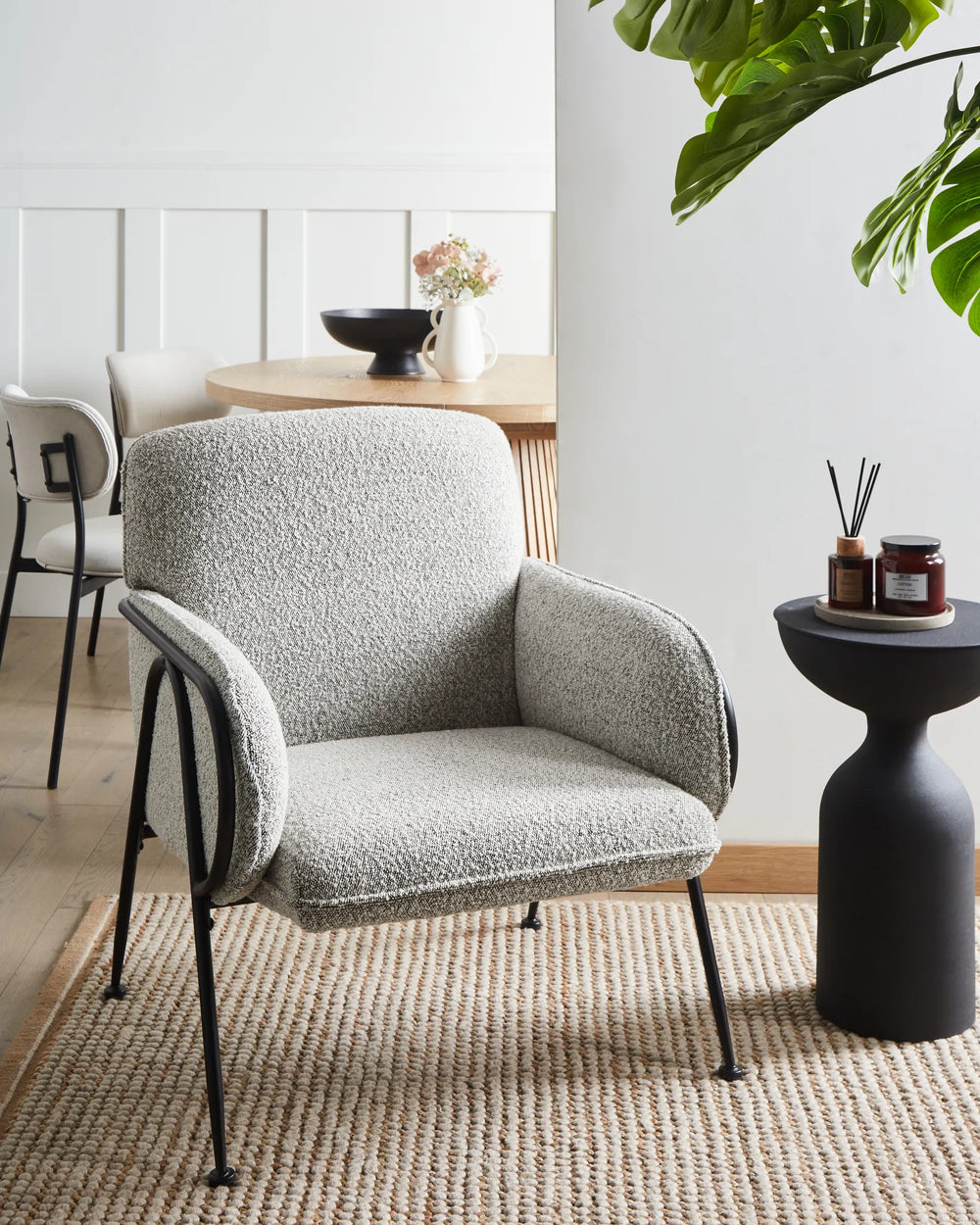 Gray armchair in a modern living room with a small table and decorative items.