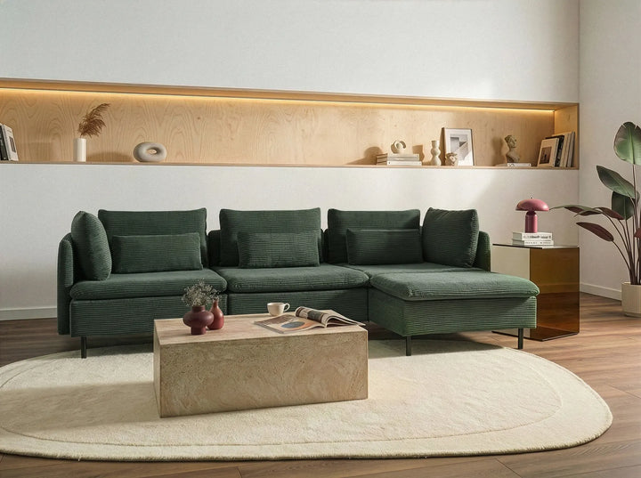 Modern living room with a green sectional sofa, wooden coffee table, and decorative items.