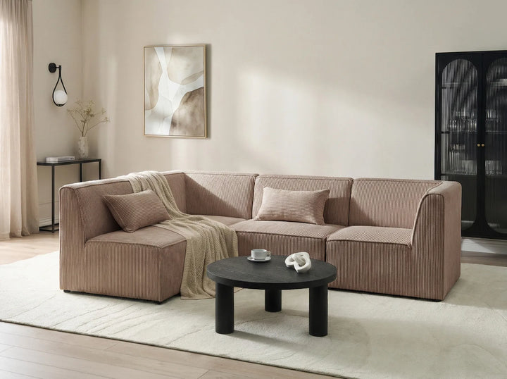 Beige sectional sofa in a living room with a coffee table and decorative items.