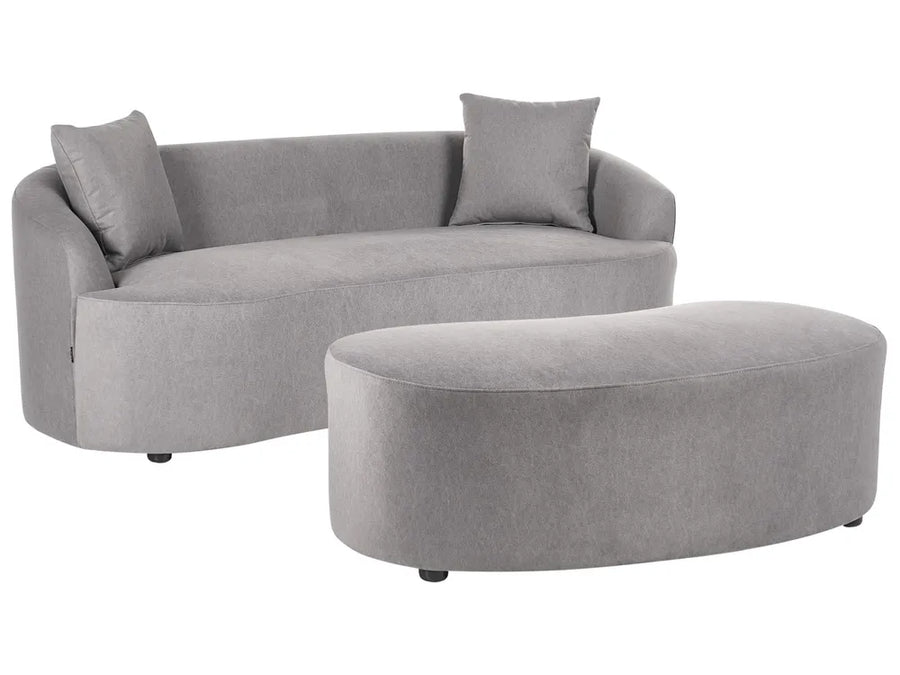 A light gray upholstered curved sofa with two matching throw pillows and a matching oval ottoman, shown on a plain white background.