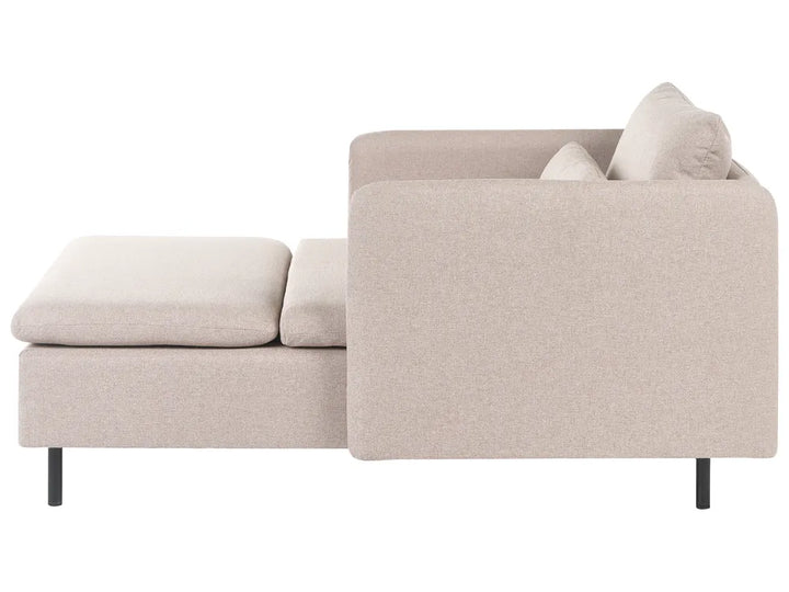 A modern sectional sofa in a light beige textured fabric, featuring a right-facing armrest with a matching back cushion, a left-facing ottoman seat, and two loose seat cushions, shown from a side profile view on a white background.