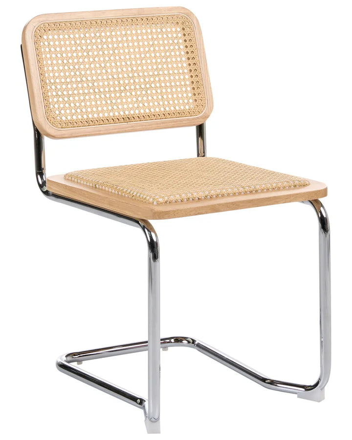A modern cantilever dining chair with a light natural wood seat and backrest, woven cane panels, and a polished chrome metal frame, shown on a solid white background.