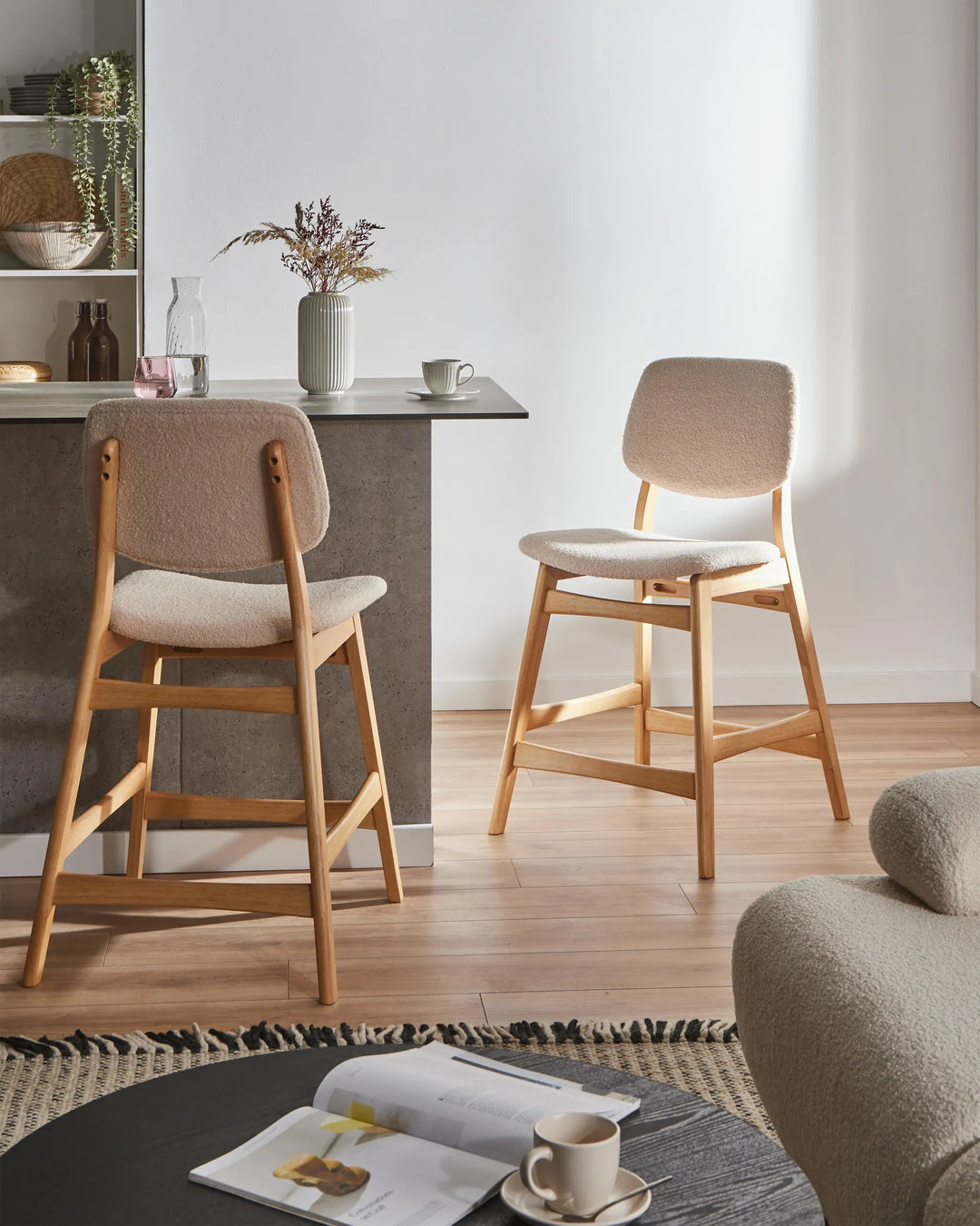 Two wooden bar stools in a modern kitchen setting with a table and decor.