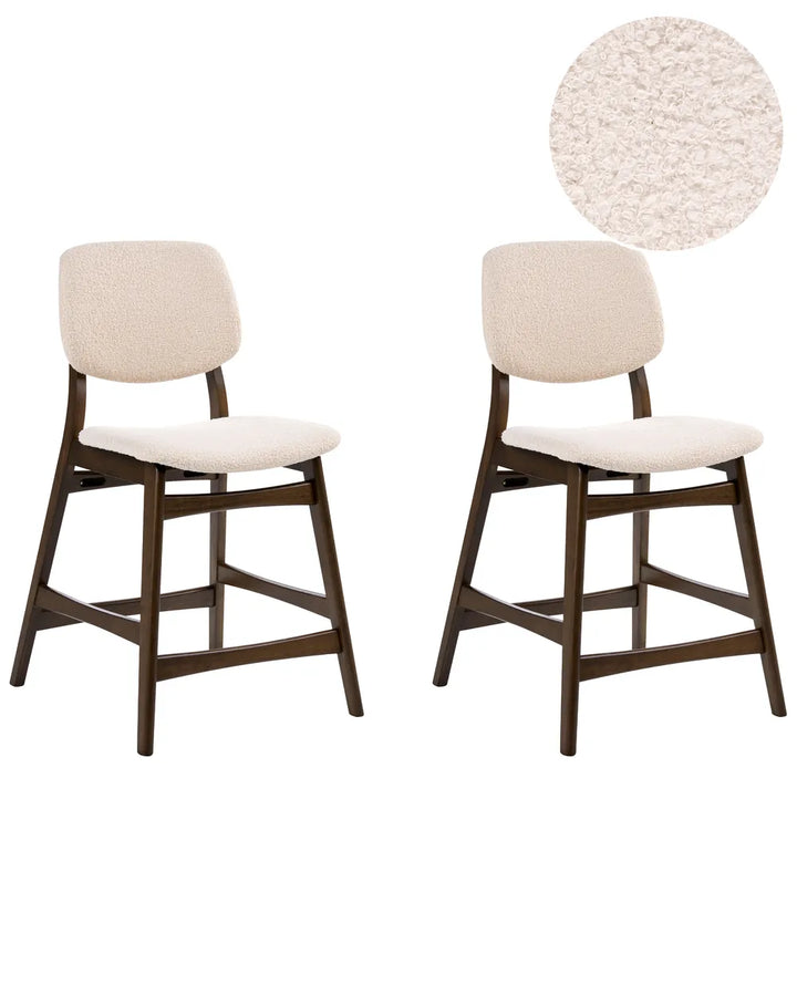 Two bar stools with white seats and dark wooden legs on a white background.
