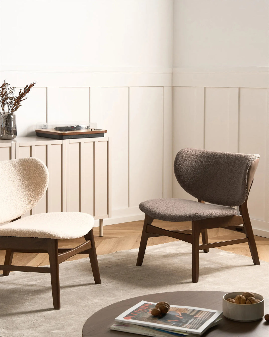 Two modern chairs in a room with a neutral color palette.