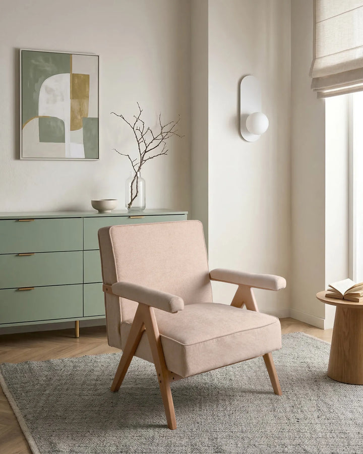 Beige armchair in a modern living room with a green cabinet and abstract art on the wall.