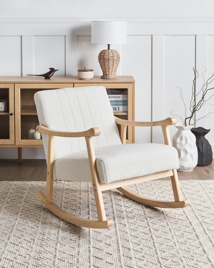 White rocking chair in a room with wooden furniture and decor.