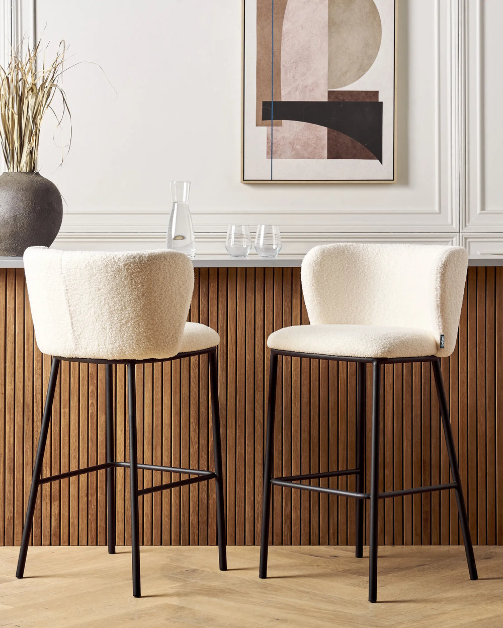 Two beige bar stools with black legs in a kitchen setting.