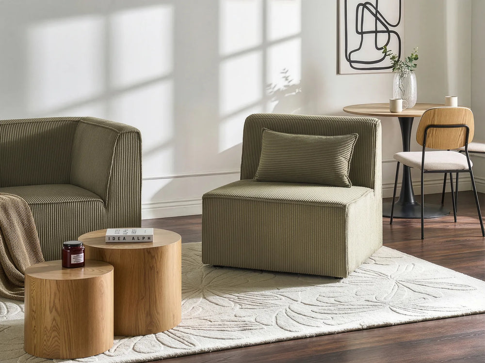 Modern living room with beige armchair, wooden coffee table, and decorative elements.