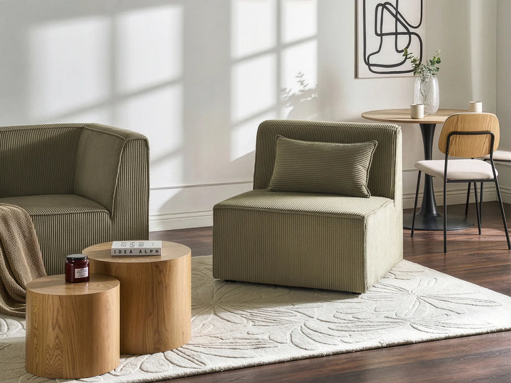 Modern living room with beige armchair, wooden coffee table, and decorative elements.